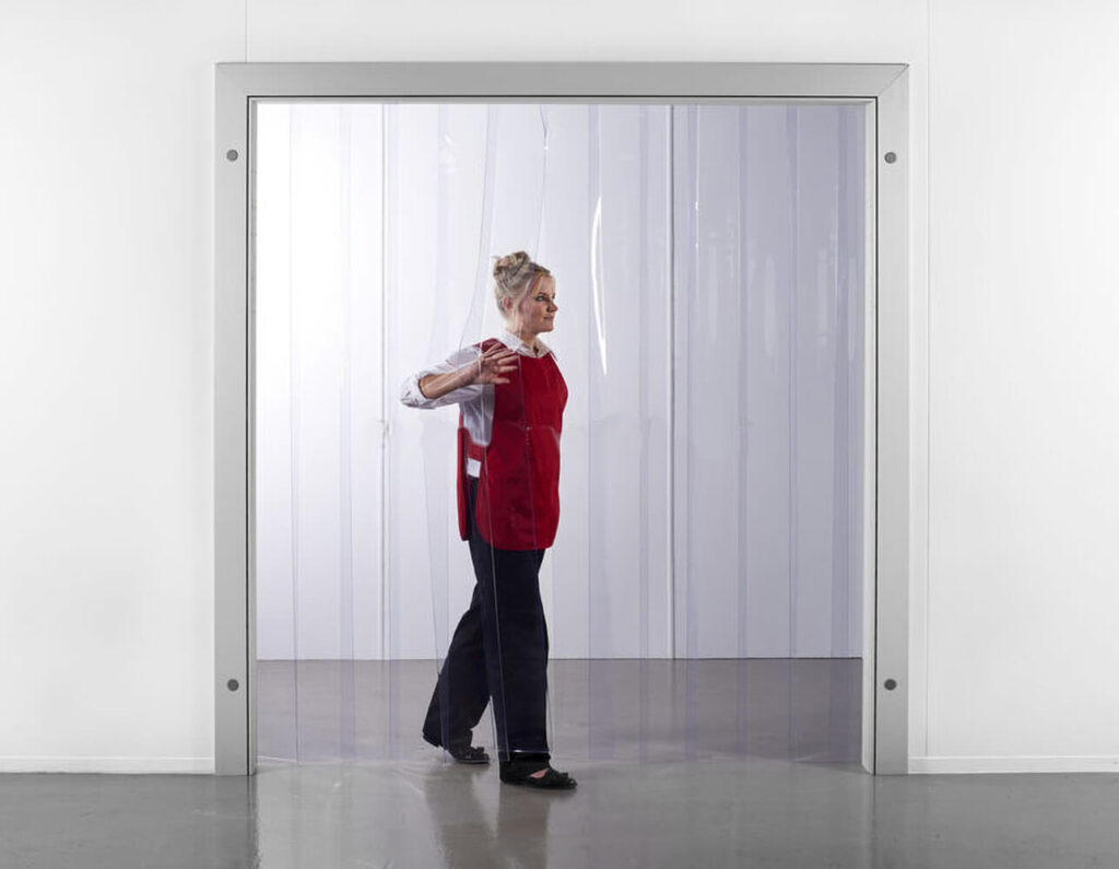 Γυναίκα περνάει μέσα από πόρτα με λωριδοκουρτίνες διάφανες